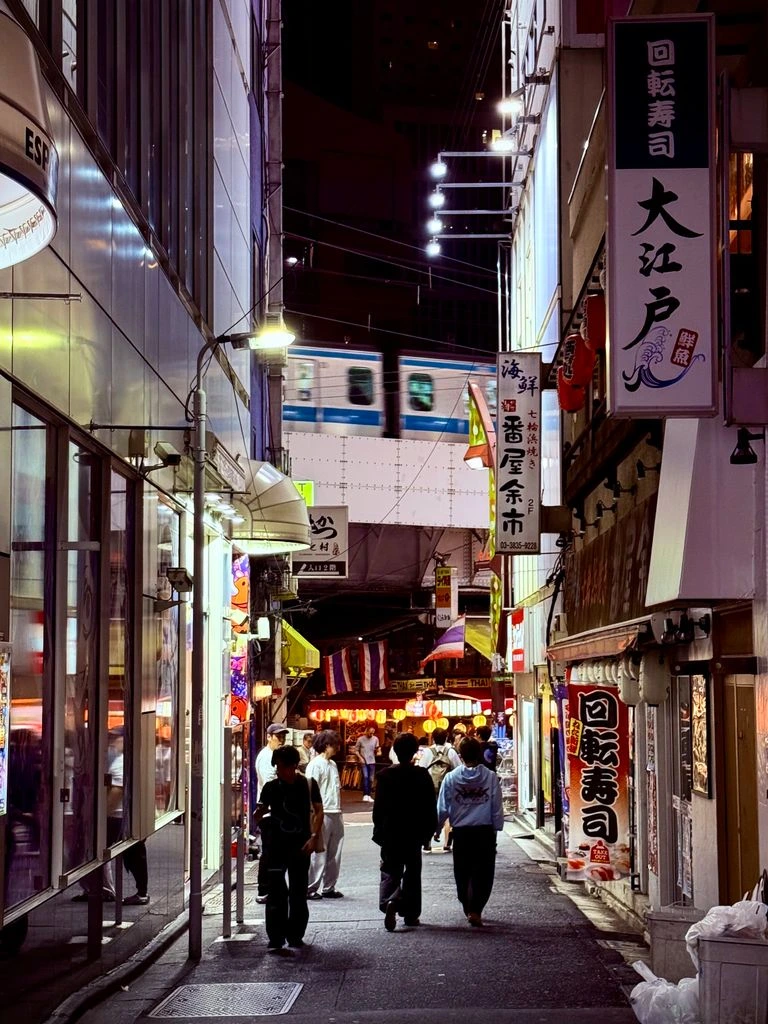 A narrow Tokyo alley stacked with glowing neon signs and rising steam.